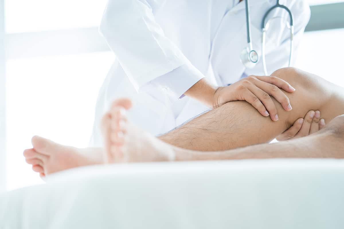 Doctor examining man's leg